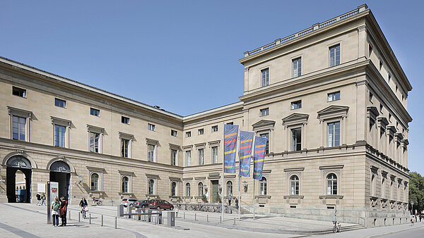 Bayerische Akademie der Wissenschaften A plaza in front of a big building with flags showing the letters BAdW, which stand for Bavarian Academy of Sciences.