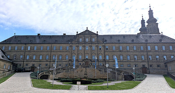 Team Retreat Banz 2025: Kloster Banz A very grand monastery with a monumental way upwards, right and left to the main entrance of the building.