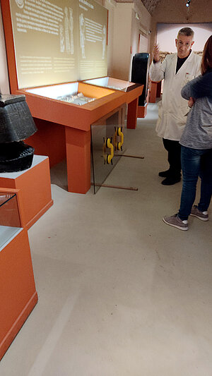 A photo of an open glass display in the museum. People discussing.